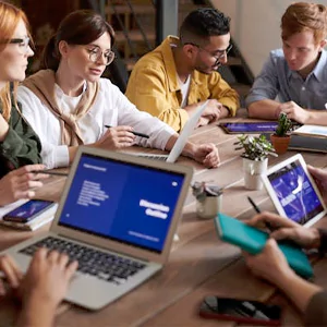 two business people’s hands next to a silver laptop